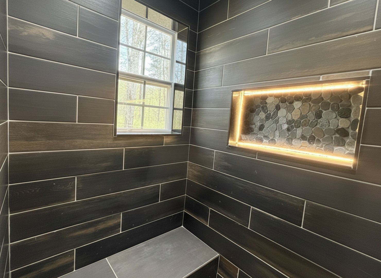 Step into this spacious walk-in shower, where you can unwind under the soothing spray while sunlight streams through the window. Enjoy the tasteful niche with ambient lighting for a truly relaxing experience.